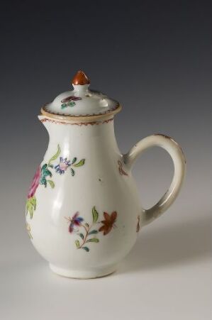  A classic ceramic teapot with a creamy off-white base color and a floral pattern in purple, pink, green, orange, and blue. Gold accents are present on the top edge and handle attachment, and the lid features a red and gold knob. The teapot is set against a plain gray background.