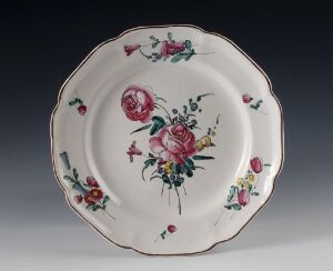 
 A decorative ceramic plate with scalloped edges featuring a vibrant floral design with a pink rose, smaller blossoms, and green foliage on a pale cream background, against a dark gray backdrop. The artist name and the title are unknown.