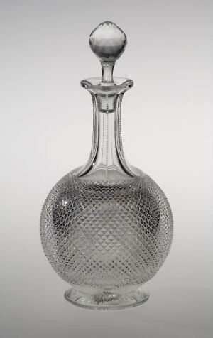  A transparent glass decanter with a diamond pattern on the body and a smooth neck, featuring a round stopper, displayed against a soft grey gradient background.