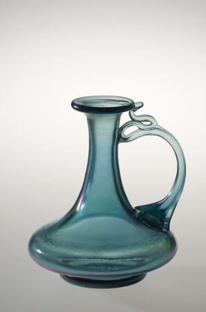  A teal glass jug with a bulbous base and slender neck, boasting a smooth round lip and curved handle, set against a light grey background.