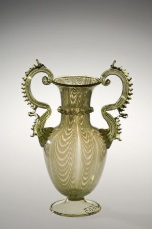  An elegant translucent pale green vase with ornate twisted handles and embossed leaf-like decorations on a light background.