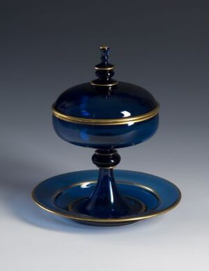  A decorative deep blue and gold covered compote or sweetmeat stand, consisting of a base plate, stem, and a spherical covered bowl with a glossy finish, set against a gradient background