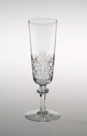  A single Hadeland Glassverk crystal champagne flute with a cut pineapple-like pattern at the base of the bowl, set against a neutral gray background, showcasing its clear, reflective surface and intricate design.