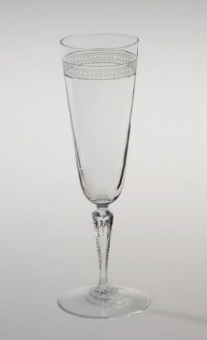  Clear crystal champagne flute by Hadeland Glassverk with a pattern of horizontal cuts on the upper bowl, a slender stem with a decorative element, on a muted background.