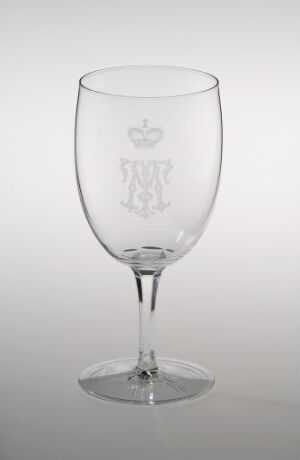  A clear blown glass goblet with engraved and cut decoration by Hadeland Glassverk, featuring an intricate monogram design on the bowl.