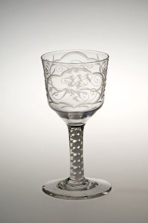  A clear glass goblet with an etched vine-like design on the bowl, a textured dot pattern on the stem, standing against a gradient grey to white background. Artist name and title are unknown.