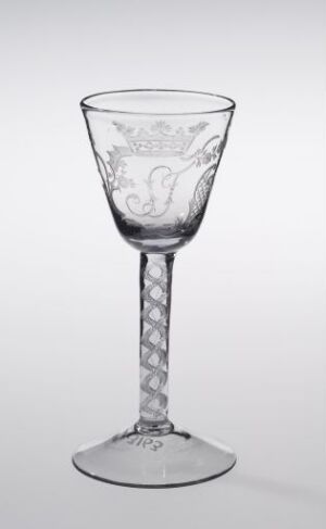  A clear glass goblet with an engraved bowl and diamond-cut pattern on the stem, set against a light gray background.