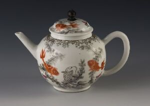  An ornately decorated porcelain teapot with a rounded body featuring grayscale imagery and vibrant orange-red floral designs, a curved spout, and a C-shaped handle, presented against a neutral gradient background.