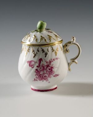  An elegant white porcelain mustache cup with a lid, decorated with a purple floral pattern, green foliage, and gold accents on the handle, rim, and base, set against a light grey background.