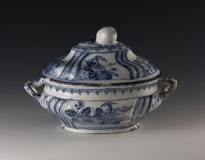  An oval-shaped ceramic tureen with a lid, featuring intricate cobalt blue patterns on a white background, with scrolled handles and a plain round knob on the lid.