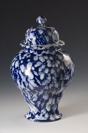  A porcelain vase with a lid, featuring a detailed blue floral design on a white background. The vase has a globular shape with a short neck and flared rim, and the lid is topped with a simple, rounded finial.