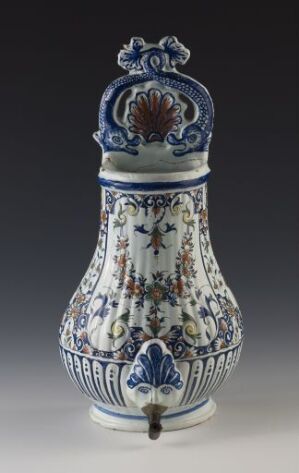  An ornate blue-and-white porcelain vase with a spout near the base and a decorative lid. The vase features intricate floral patterns and a scene with human figures, suggesting traditional or mythological storytelling through its design.