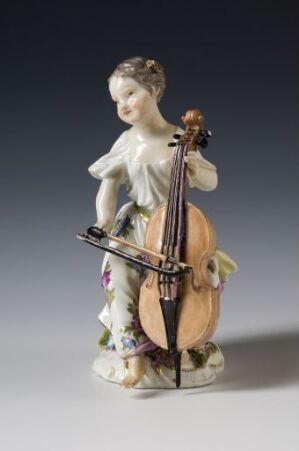  Figurine of a young woman in an 18th-century style dress playing a cello, with an intricate design featuring soft blues, pinks, and greens on an off-white background.