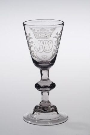  Transparent glass wine goblet with decorative etchings on the bell-shaped bowl, center detail on the stem, and stable circular foot, against a light background.