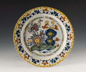  Antique hand-painted ceramic plate with intricate blue, yellow, orange, and green floral and geometric patterns on a white background, showcasing traditional craftsmanship.