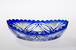  A decorative bowl with a deep cobalt blue color and intricate white patterns, resting on a flat surface against a plain background.