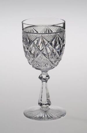  An intricately cut crystal glass named Nordkapp, created by Hadeland Glassverk, with geometric faceted patterns, displayed against a neutral background.