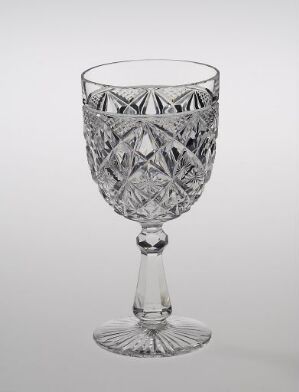  A clear crystal glass titled "Nordkapp" from Hadeland Glassverk, featuring intricate blown and cut designs with geometric patterns on the bowl, a slender stem, and a starburst pattern on the base against a neutral background.