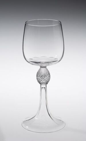  "Diamant" wine glass by Hadeland Glassverk, featuring a clear, faceted crystal design with a diamond-like element on the stem, set against a gradient gray background.