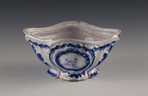  A rectangular ceramic vessel with scalloped edges, predominantly white, adorned with deep cobalt blue floral motifs, displayed against a gradient gray background.