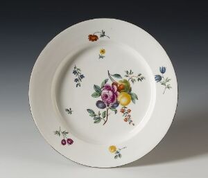  A decorative white ceramic plate with a hand-painted design of multi-colored flowers and fruits, featuring vibrant hues of pink, purple, yellow, and blue against the white background.