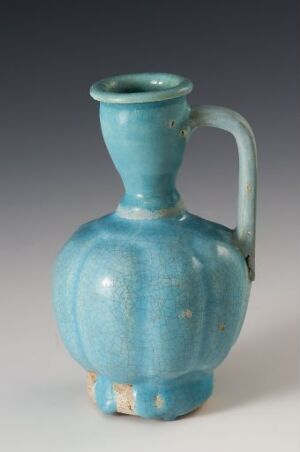  A historical turquoise ceramic jug with a bulbous body, cylindrical neck, and single handle, displaying a rich, variegated glaze.