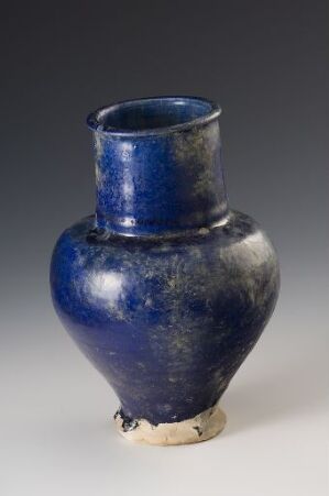  An aged ceramic vase with a deep blue glaze, showing slight wear and having a bulbous body with a short neck, displayed against a gradient gray background. Artist name and title remain unknown.