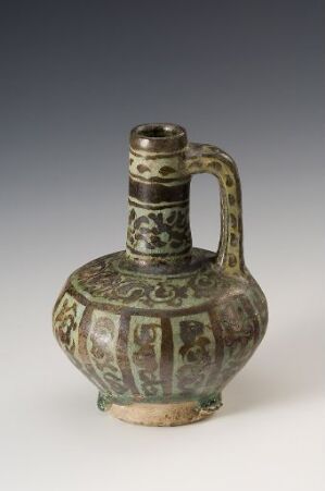  Antique ceramic jug with bulbous body and cylindrical neck, decorated with muted green, tan, and brown floral and abstract designs, on a neutral gray background.