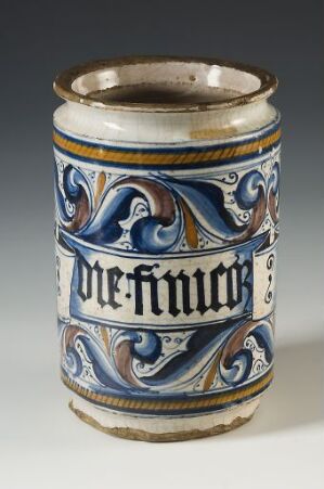  An ornately designed ceramic beer stein with the words "Prost Neujahr" in blue on a white background, surrounded by blue scrollwork and with a metallic rim at the top.