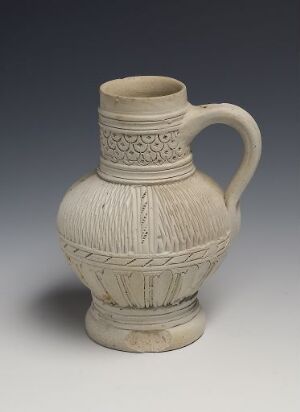  A ceramic jug with an embossed and patterned design in pale beige stands against a gradient gray background, displaying intricate craftsmanship and a bygone era's aesthetic.