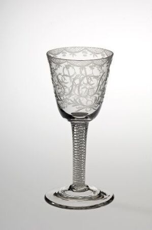  An elegant clear glass goblet with a tulip-shaped bowl featuring intricate etched patterns, a helical rope-like stem, and a modestly flared foot, against a light gray gradient background.