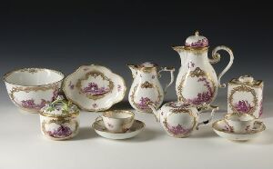  An opulent porcelain tea set featuring a coffee or teapot, creamer, sugar bowl, waste bowl, and a cup with saucer, all adorned with deep purple floral patterns and gold trimmings on a glossy white base, displayed against a neutral background.