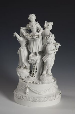  A detailed white porcelain figurine depicting an 18th-century European social scene with a central female figure surrounded by two men and two cherubs, set against a plain background.