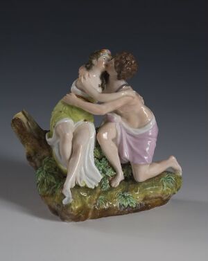  A porcelain decorative piece titled "Daggruppe" featuring two figures in classical attire intimately interacting on a naturalistic base with a tree stump, rendered in delicate pastel colors with fine attention to detail.