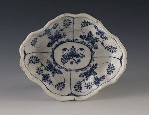  A traditional blue-and-white porcelain plate with a scalloped edge featuring symmetrical floral designs.