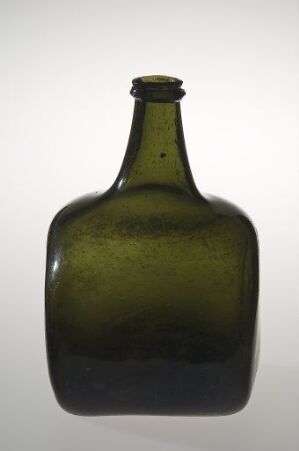  An old-fashioned olive green glass bottle with a short neck and rounded rectangular body, showcasing subtle color gradients and light reflections.