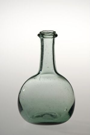  A vintage-style clear glass bottle with a green tint, displaying a rounded base and a slender neck, against a plain light gray background.