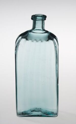  An antique, rectangular glass bottle with ribbed sides and a greenish-blue tint, set against a light background.