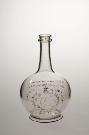  A transparent glass bottle with intricate engravings inside, displayed against a soft grey background.