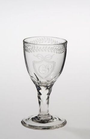  A clear etched glass goblet with decorative patterns and a central emblem displayed against a white to light gray gradient background. Artist name and title are unknown.