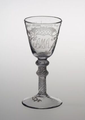  A clear glass goblet with an etched design in the bowl and a twisted stem, standing against a light grey background.