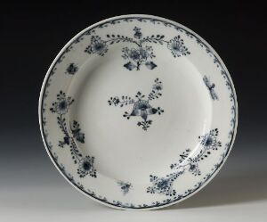  A porcelain plate with elegant cobalt blue floral patterns on a white background, showcasing traditional craftsmanship with a detailed design extending from the center towards the rim. Artist unknown.