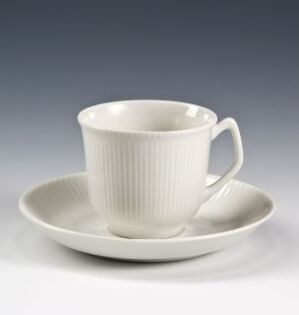  White feldspar porcelain cup and saucer set with vertical relief decoration, designed by Tias Eckhoff. The saucer has a subtly square shape with rounded corners, and the cup is cylindrical with a comfortable handle.