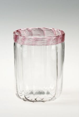  A cylindrical clear glass with red swirls around the rim against a white gradient background.