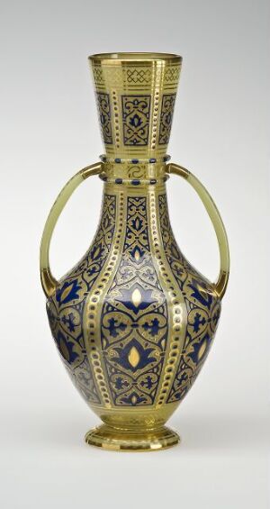  An ornate gold and cobalt blue vase with an elongated neck, bulbous body, and symmetrical handles, featuring intricate geometric patterns and embellishments.