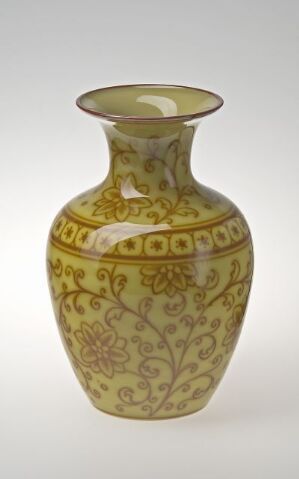  A traditional creamy yellow vase with darker yellow floral and geometric patterns, featuring a curvaceous body and a slightly flared rim.