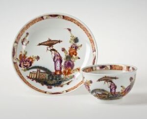  Antique Chinese porcelain plate and bowl with detailed scenes of bridges, figures, animals, and nature in vibrant shades of orange, purple, red, and green on a light background.