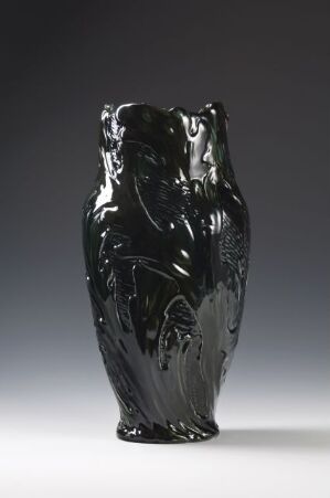  A glossy black vase with textured, wavy lines on its surface, standing against a light-grey background.