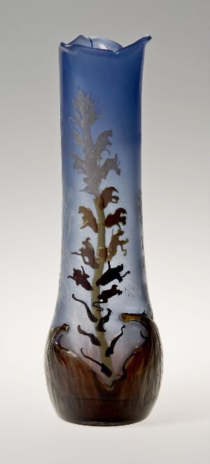  A tall, artistically crafted vase with a color gradient transitioning from dark brown at the bottom to sky blue at the top, adorned with a floral pattern in white, cream, red, and violet, with an uneven rim.