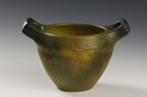  A medium-sized ceramic vessel with a rich olive green mottled glaze and two stubby handles, set against a neutral gray gradient background.